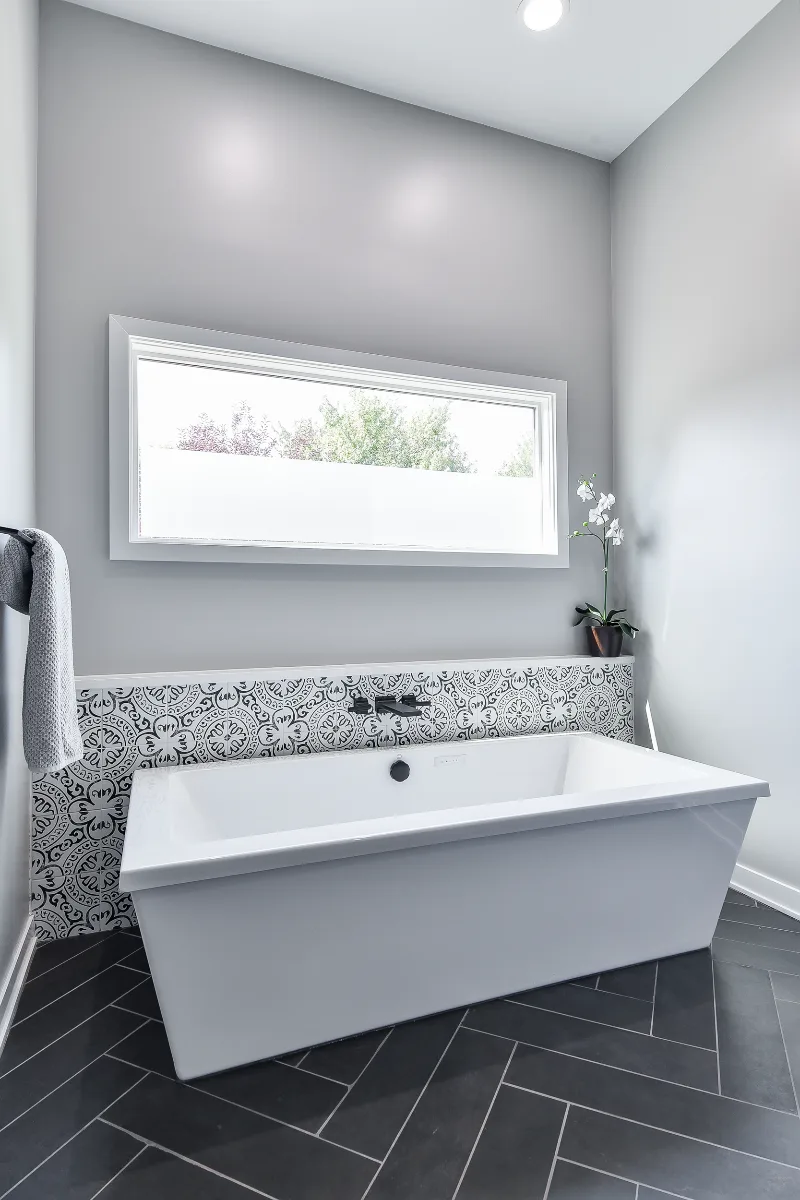 A modern-black-white primary bath remodel in Franklin, TN. Bellmont 1600 Studio White cabinetry, Cambria Deligatie quartz, Kohler Pivotal Matte Black, MTI Andrea tub, and MSI Kenzzi Paloma tile by Sebring Design Build.