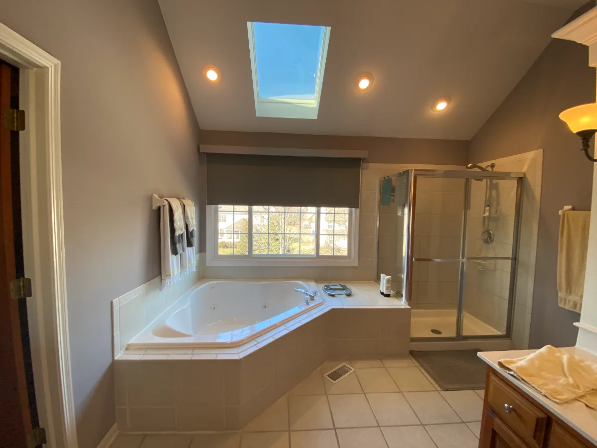 A modern-unique primary bath remodel in Brentwood, TN. Pearl cabinetry, Hanstone Tranquility quartz, MTI Rectangle soaking tub, Lunada Bay Aura Pearl accent tile, and Moen Polished Nickel by Sebring Design Build.