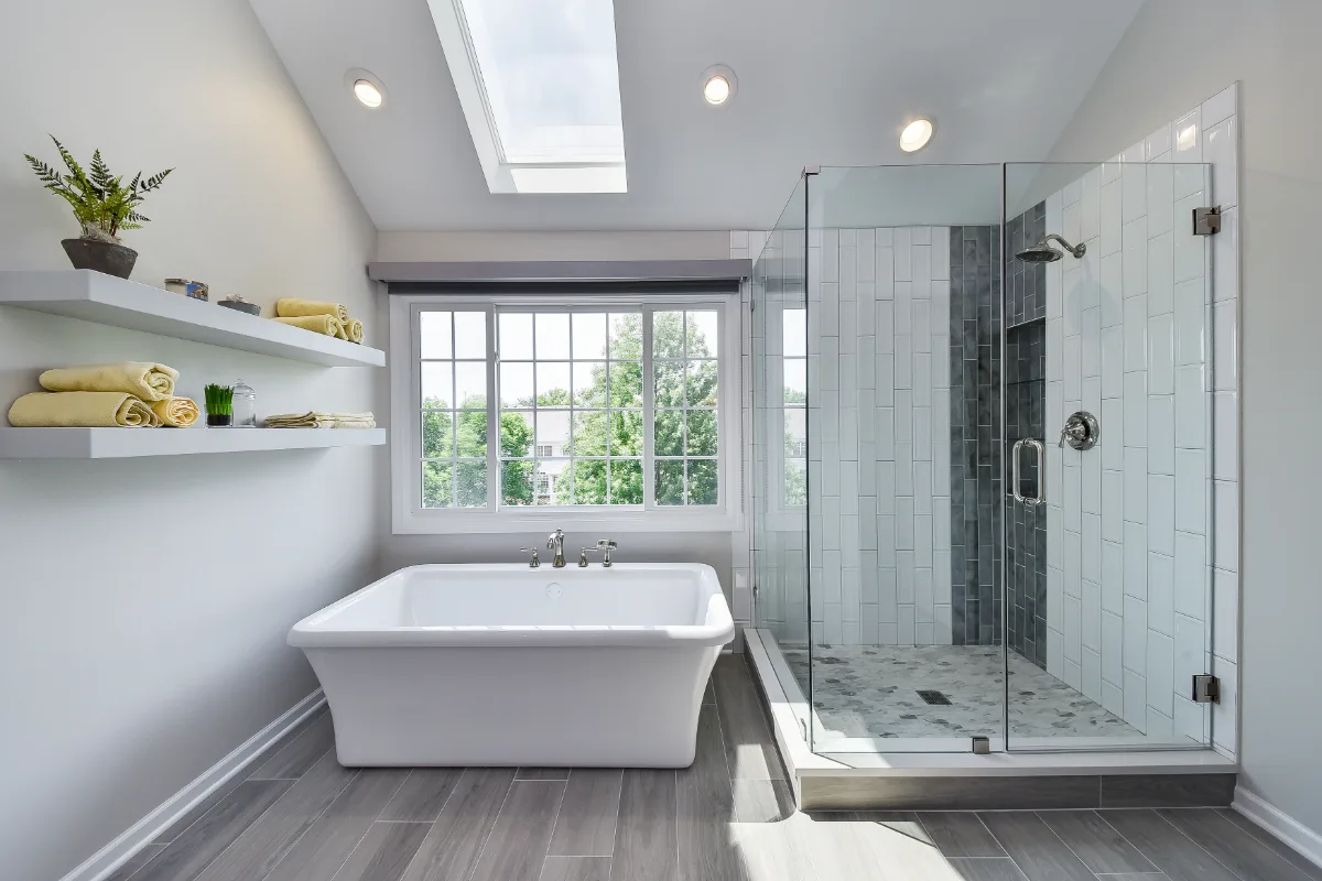 A modern-unique primary bath remodel in Brentwood, TN. Pearl cabinetry, Hanstone Tranquility quartz, MTI Rectangle soaking tub, Lunada Bay Aura Pearl accent tile, and Moen Polished Nickel by Sebring Design Build.