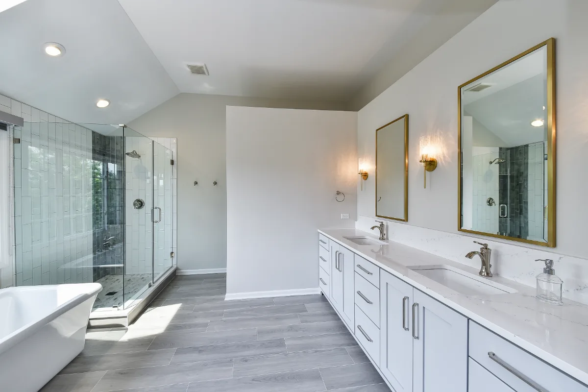 A modern-unique primary bath remodel in Brentwood, TN. Pearl cabinetry, Hanstone Tranquility quartz, MTI Rectangle soaking tub, Lunada Bay Aura Pearl accent tile, and Moen Polished Nickel by Sebring Design Build.
