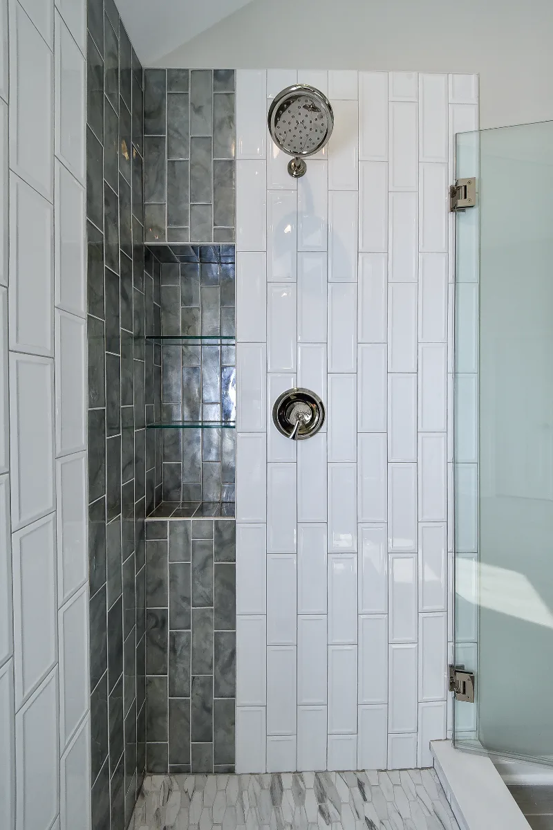 A modern-unique primary bath remodel in Brentwood, TN. Pearl cabinetry, Hanstone Tranquility quartz, MTI Rectangle soaking tub, Lunada Bay Aura Pearl accent tile, and Moen Polished Nickel by Sebring Design Build.