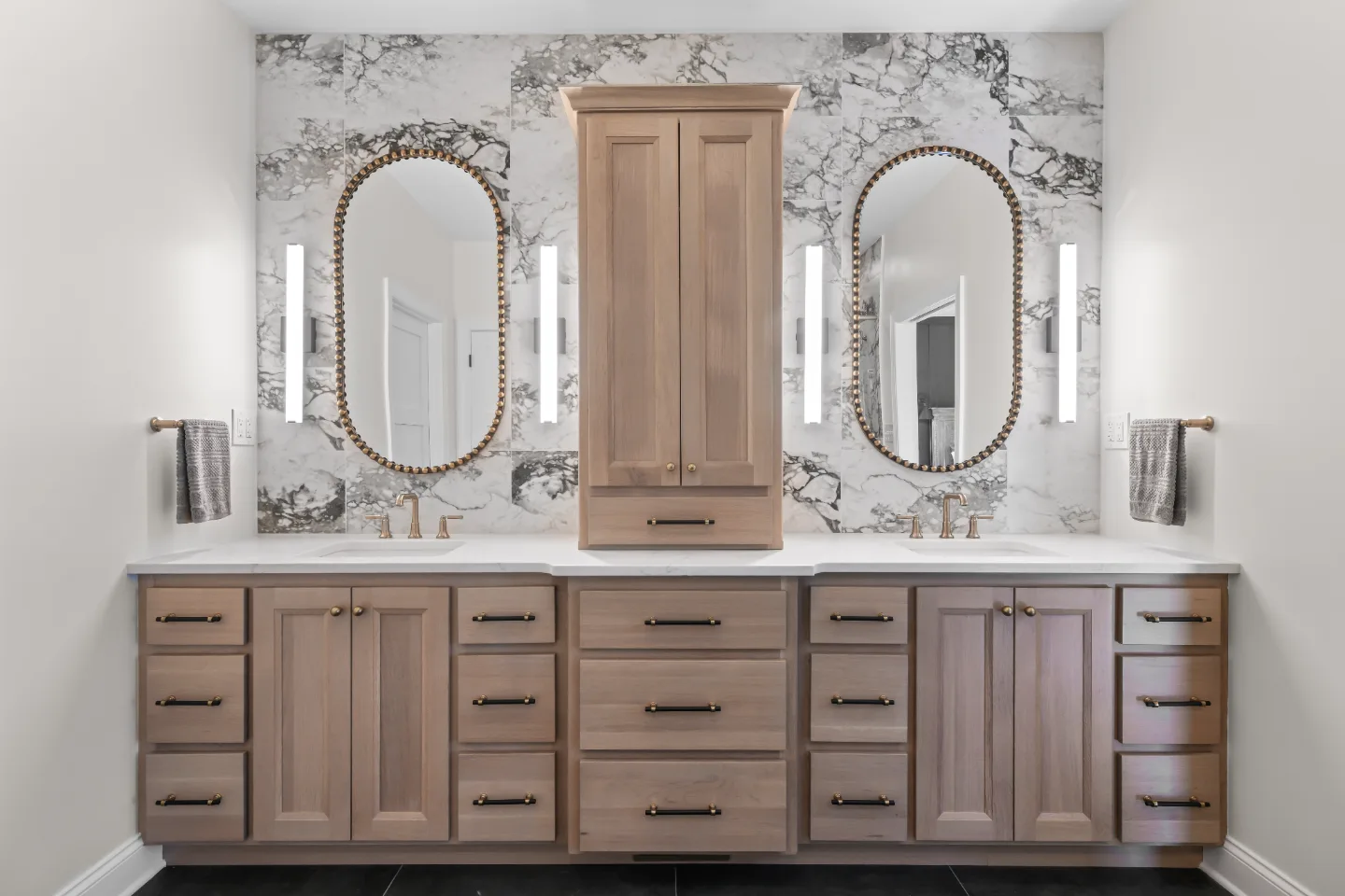A transitional-bold primary bath remodel in Columbia, TN. White Oak quarter-sawn cabinetry, Calacatta Monaco quartz, and a bold Kenridge Ribbon Black feature wall by Sebring Design Build.