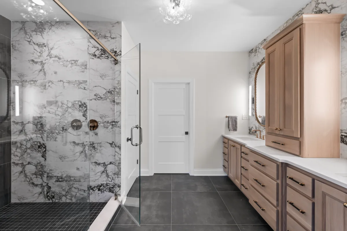 A transitional-bold primary bath remodel in Columbia, TN. White Oak quarter-sawn cabinetry, Calacatta Monaco quartz, and a bold Kenridge Ribbon Black feature wall by Sebring Design Build.