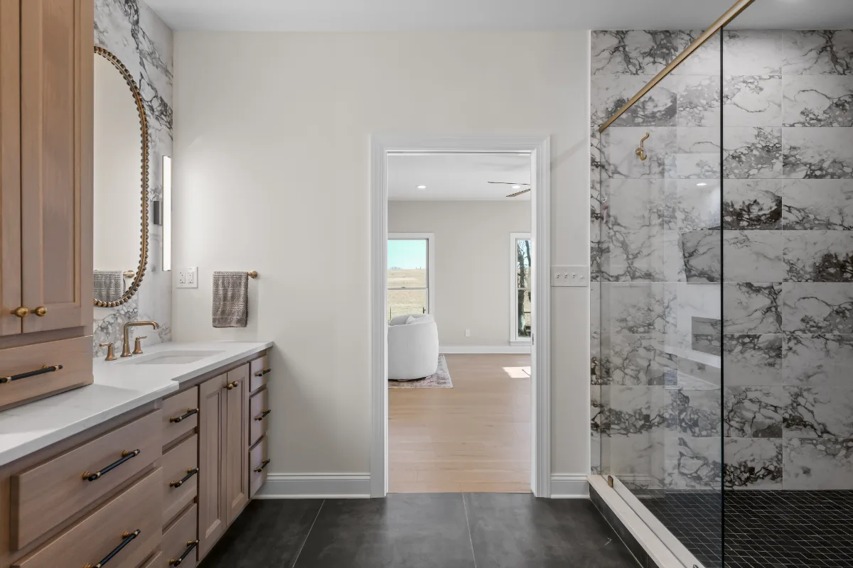 A transitional-bold primary bath remodel in Columbia, TN. White Oak quarter-sawn cabinetry, Calacatta Monaco quartz, and a bold Kenridge Ribbon Black feature wall by Sebring Design Build.