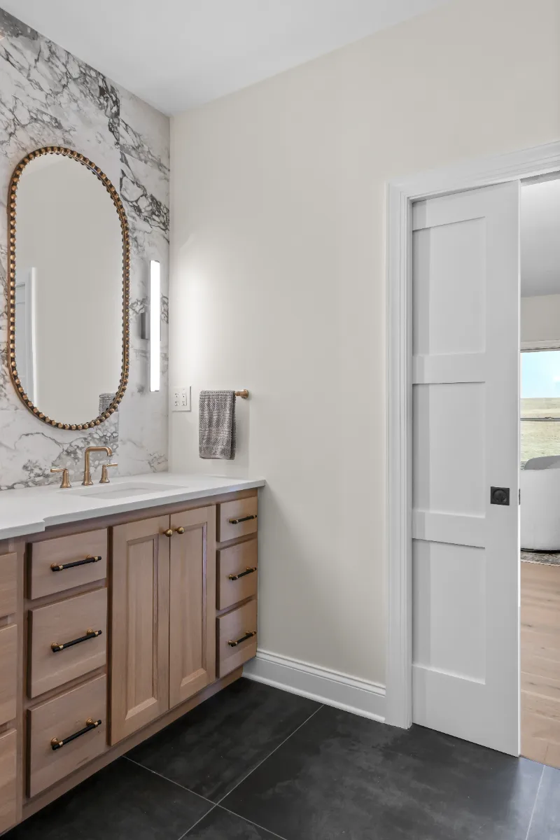 A transitional-bold primary bath remodel in Columbia, TN. White Oak quarter-sawn cabinetry, Calacatta Monaco quartz, and a bold Kenridge Ribbon Black feature wall by Sebring Design Build.