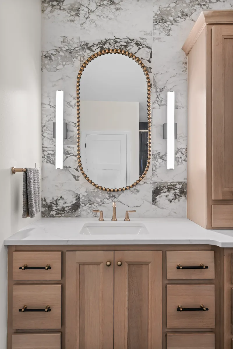 A transitional-bold primary bath remodel in Columbia, TN. White Oak quarter-sawn cabinetry, Calacatta Monaco quartz, and a bold Kenridge Ribbon Black feature wall by Sebring Design Build.