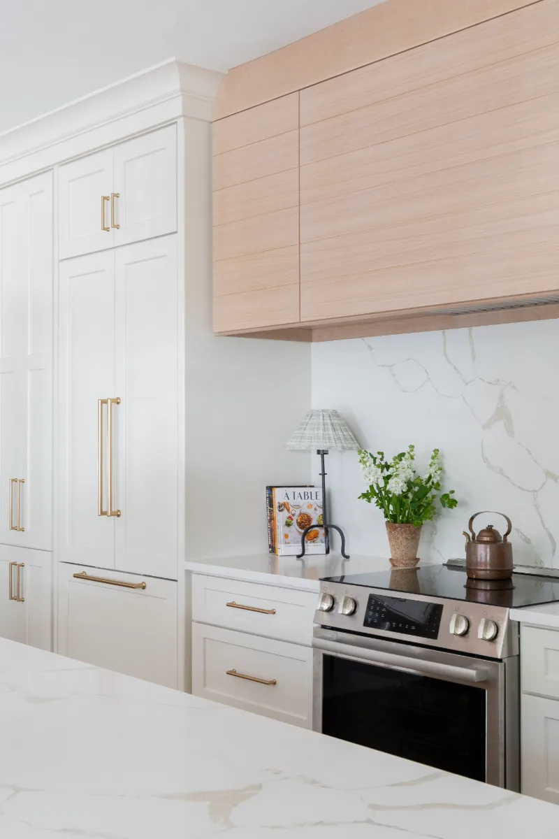 A coastal-elegant kitchen remodel in Willowsprings, Franklin TN 37064. Custom Champagne cabinetry, Calacatta Gold quartz, and Champagne Bronze fixtures by Sebring Design Build.