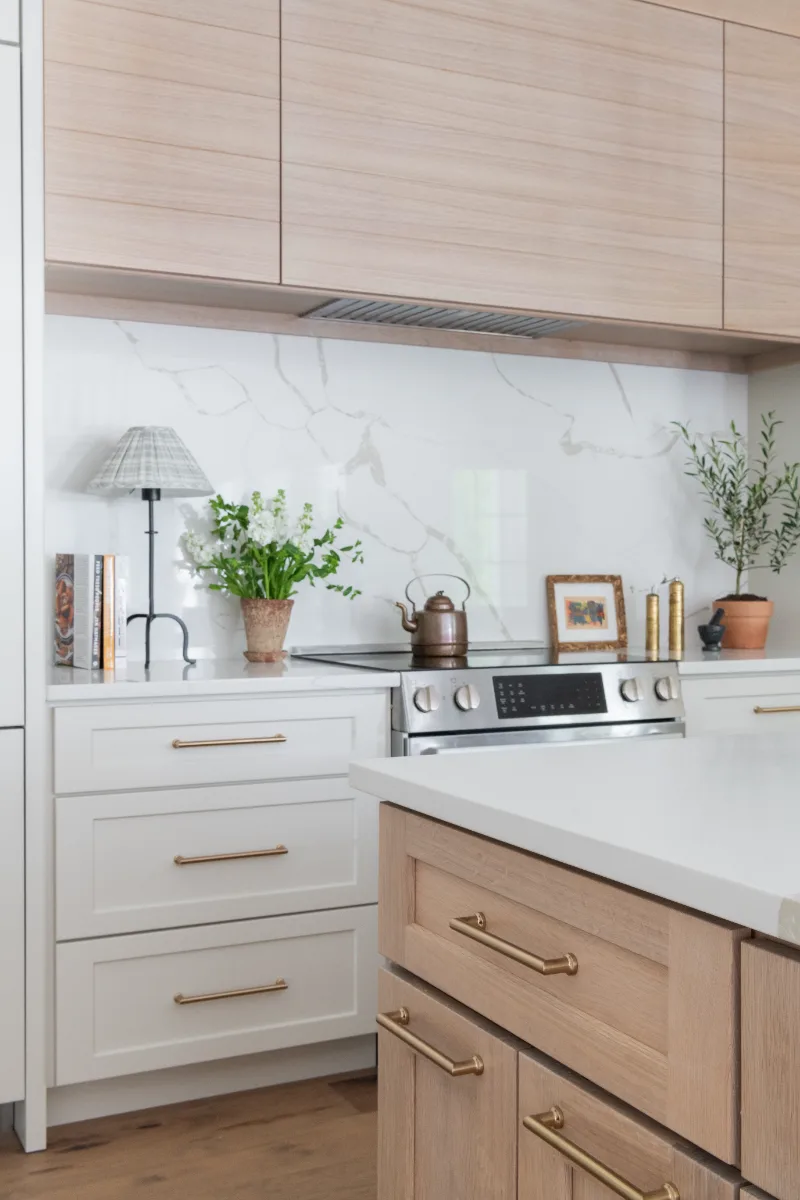 A coastal-elegant kitchen remodel in Willowsprings, Franklin TN 37064. Custom Champagne cabinetry, Calacatta Gold quartz, and Champagne Bronze fixtures by Sebring Design Build.