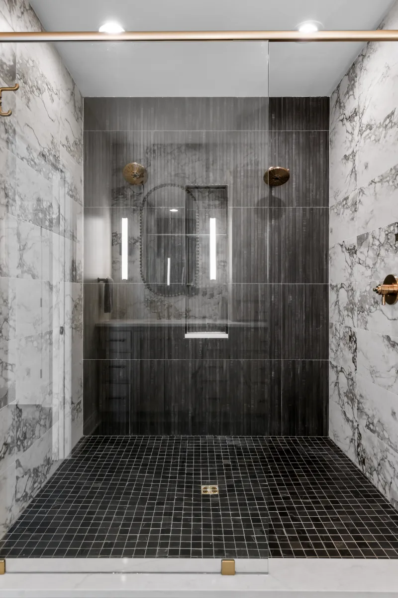 A transitional-bold primary bath remodel in Columbia, TN. White Oak quarter-sawn cabinetry, Calacatta Monaco quartz, and a bold Kenridge Ribbon Black feature wall by Sebring Design Build.
