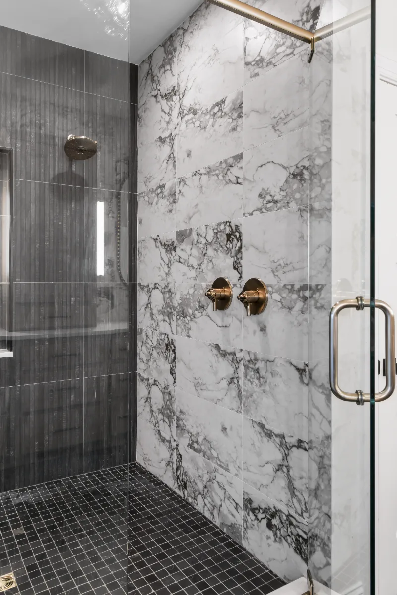 A transitional-bold primary bath remodel in Columbia, TN. White Oak quarter-sawn cabinetry, Calacatta Monaco quartz, and a bold Kenridge Ribbon Black feature wall by Sebring Design Build.