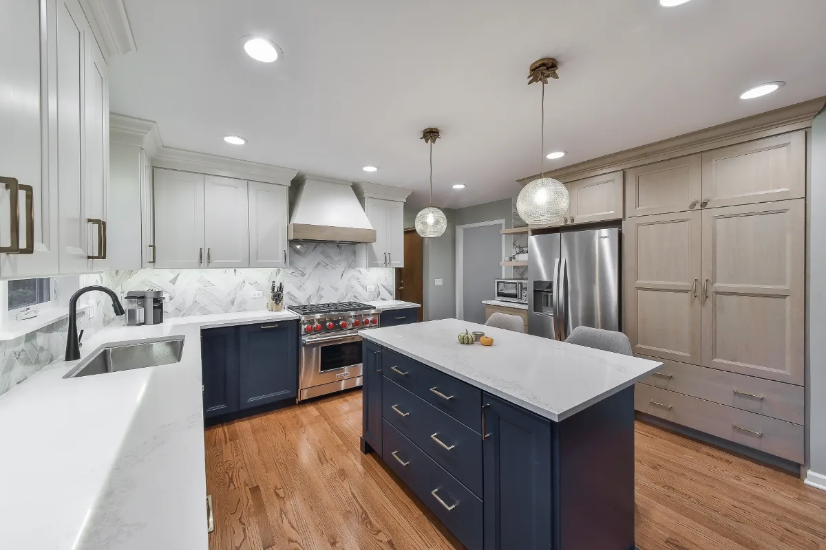 A modern-coastal kitchen remodel in Brentwood, Tennessee. Two-tone cabinetry, Caesarstone Calacatta Nuvo, and Matte Black fixtures by Sebring Design Build.