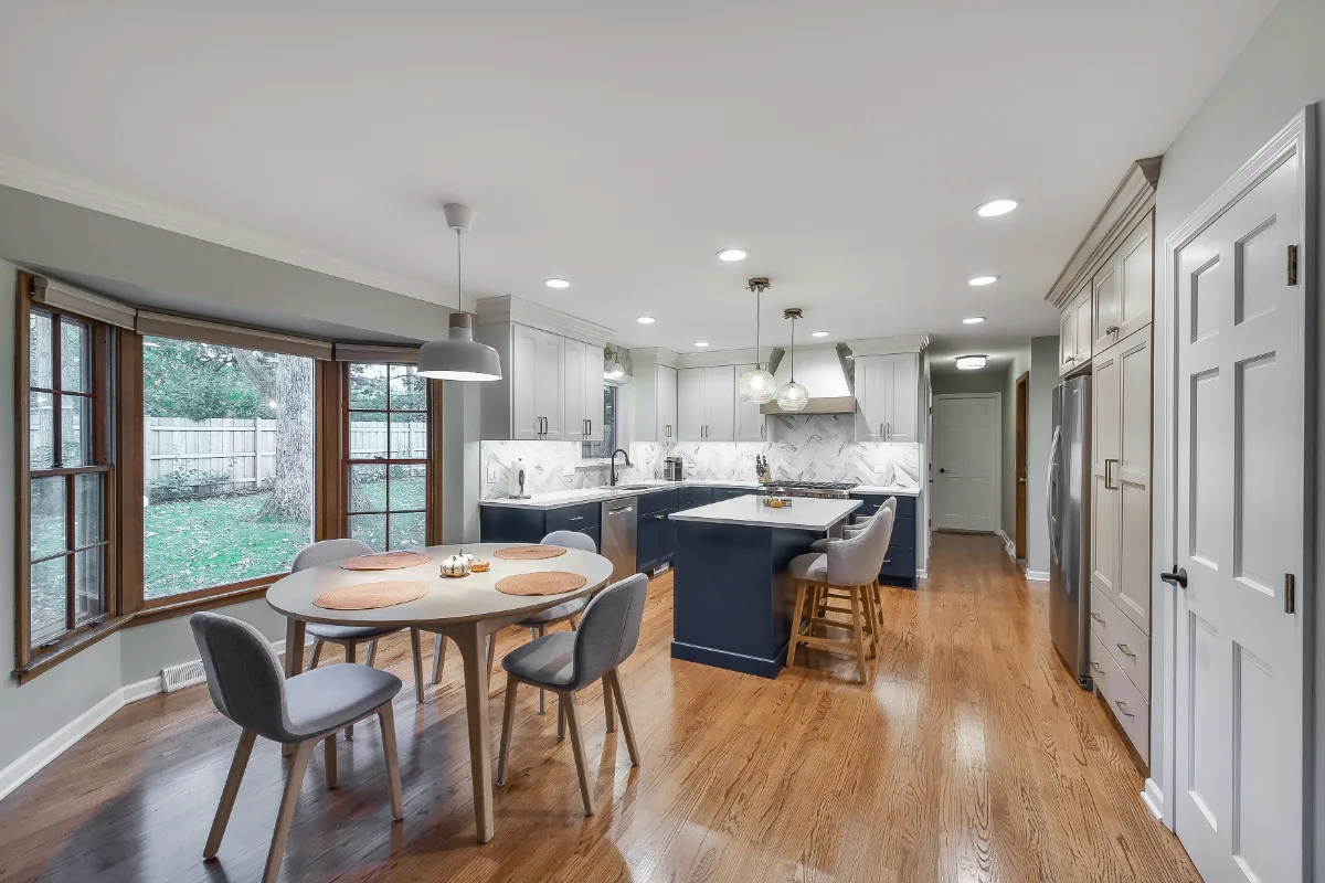 A modern-coastal kitchen remodel in Brentwood, TN. Two-tone cabinetry in Soft White and Midnight, Caesarstone Calacatta Nuvo, and Matte Black fixtures by Sebring Design Build.