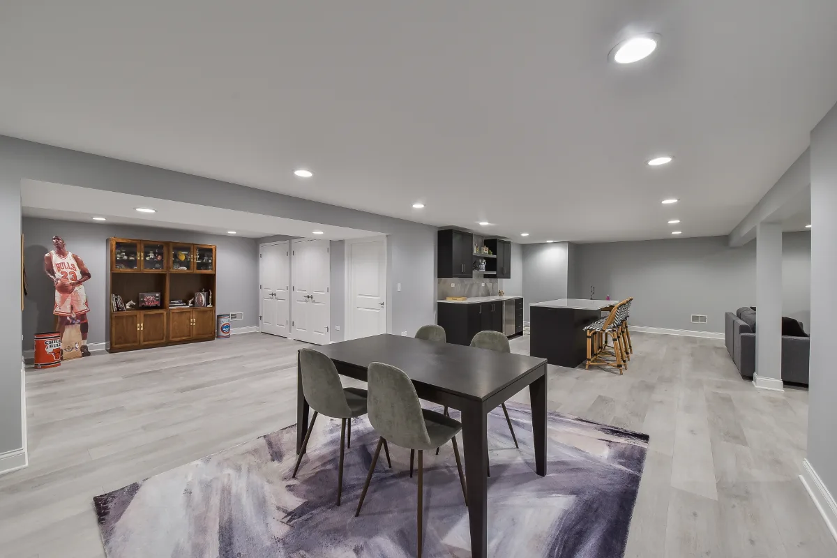 A modern-cool basement remodel in Brentwood, TN with a Matte Black bar, Corian Coarse Carrara quartz, Moen Genta faucet, and Virginia Tile Deco Anthology guest bath floor by Sebring Design Build.