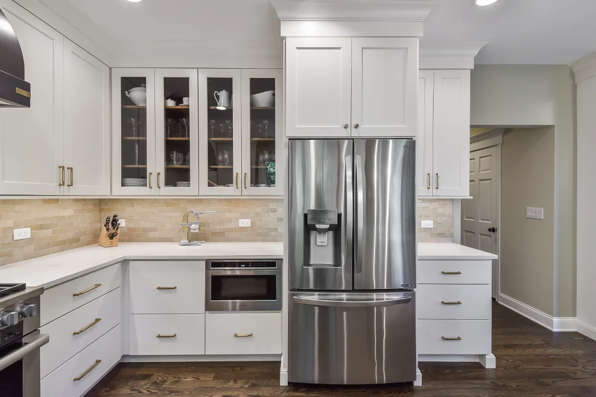 A transitional-organic kitchen remodel in Brentwood, TN. CWP Swiss Coffee and Hickory Praline cabinetry, Caesarstone Calacatta Nuvo quartz, and Delta Cassidy Champagne Bronze fixtures by Sebring Design Build.