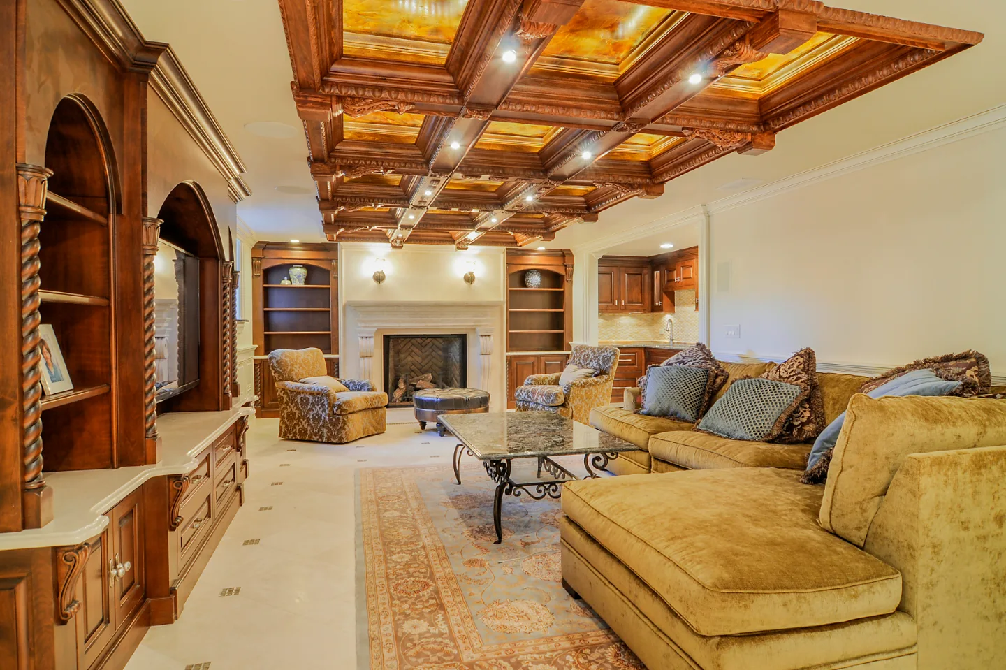 A traditional-intricate basement remodel in Franklin, TN. Coffered ceiling, custom carpentry, built-in entertainment unit, fireplace, bar, guest bath, gym, and dining room by Sebring Design Build.