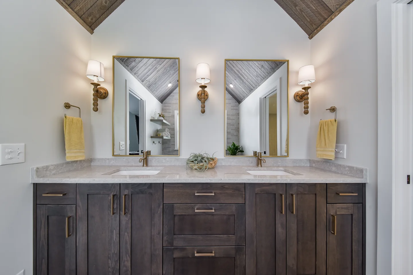 A rustic-warm primary bath remodel in Franklin, TN. Bellmont Alder Folkstone cabinetry, Orion Blanco Mist quartz, Delta Trinsic Champagne Bronze, Kohler Sunstruck tub, and Cassettone Honey Nut wood-look floor tile by Sebring Design Build.