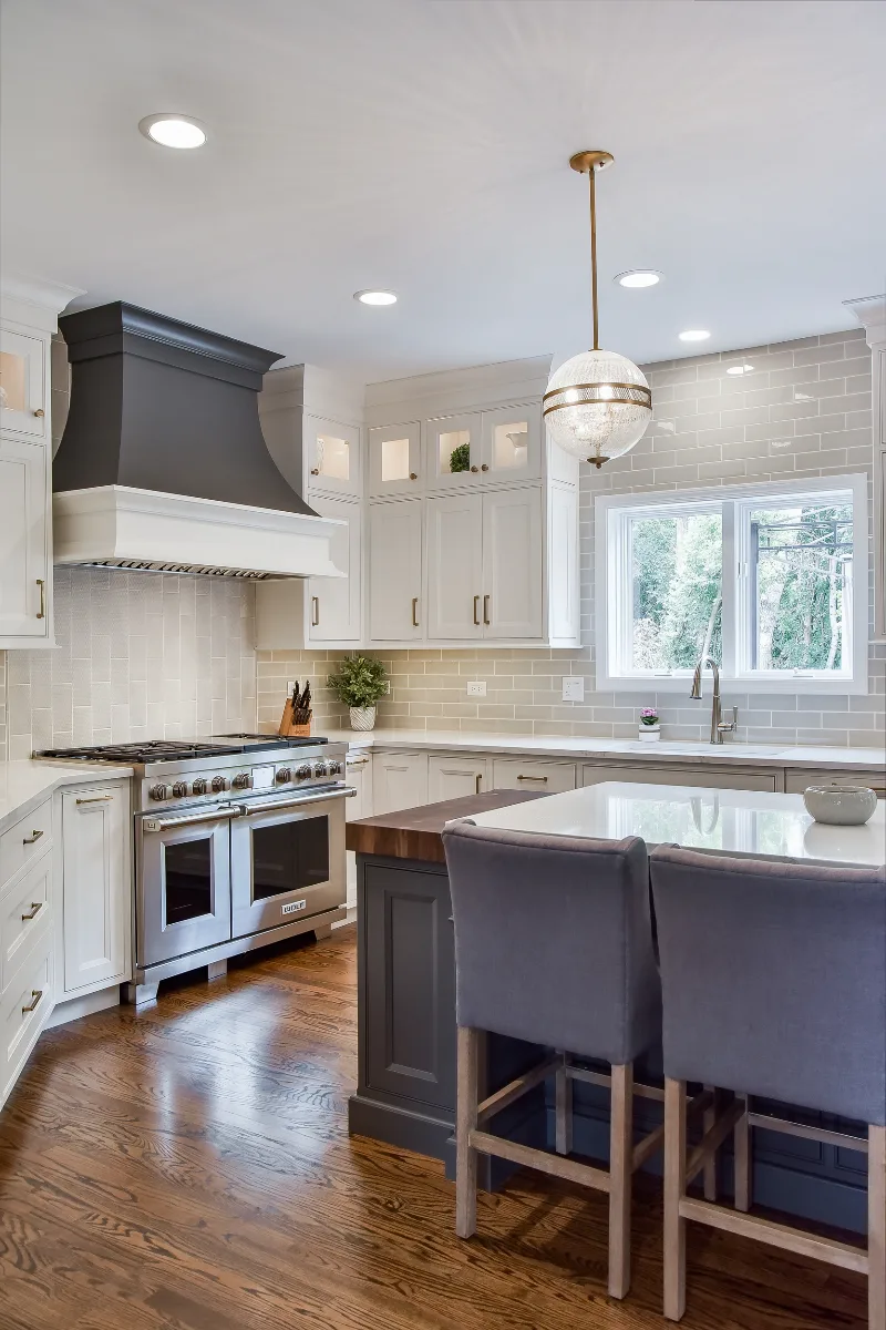 A transitional-warm kitchen and living room remodel in Brentwood, TN. Snowbound and Urban Bronze CWP cabinetry, Orion Calacatta Aria quartz, Black Walnut island top, and Sonoma Stellar backsplash by Sebring Design Build.