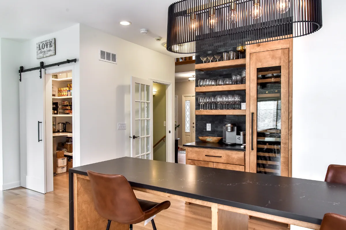 A modern-rustic kitchen, pantry, bar, and dining remodel in Brentwood, TN. CWP Bunker Hill Black and Fruitwood cabinetry with Cambria Charlestown and Colton quartz by Sebring Design Build.