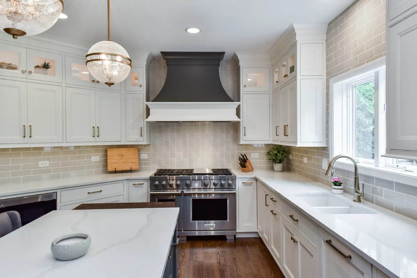 A transitional-warm kitchen and living room remodel in Brentwood, TN. Snowbound and Urban Bronze CWP cabinetry, Orion Calacatta Aria quartz, Black Walnut island top, and Sonoma Stellar backsplash by Sebring Design Build.