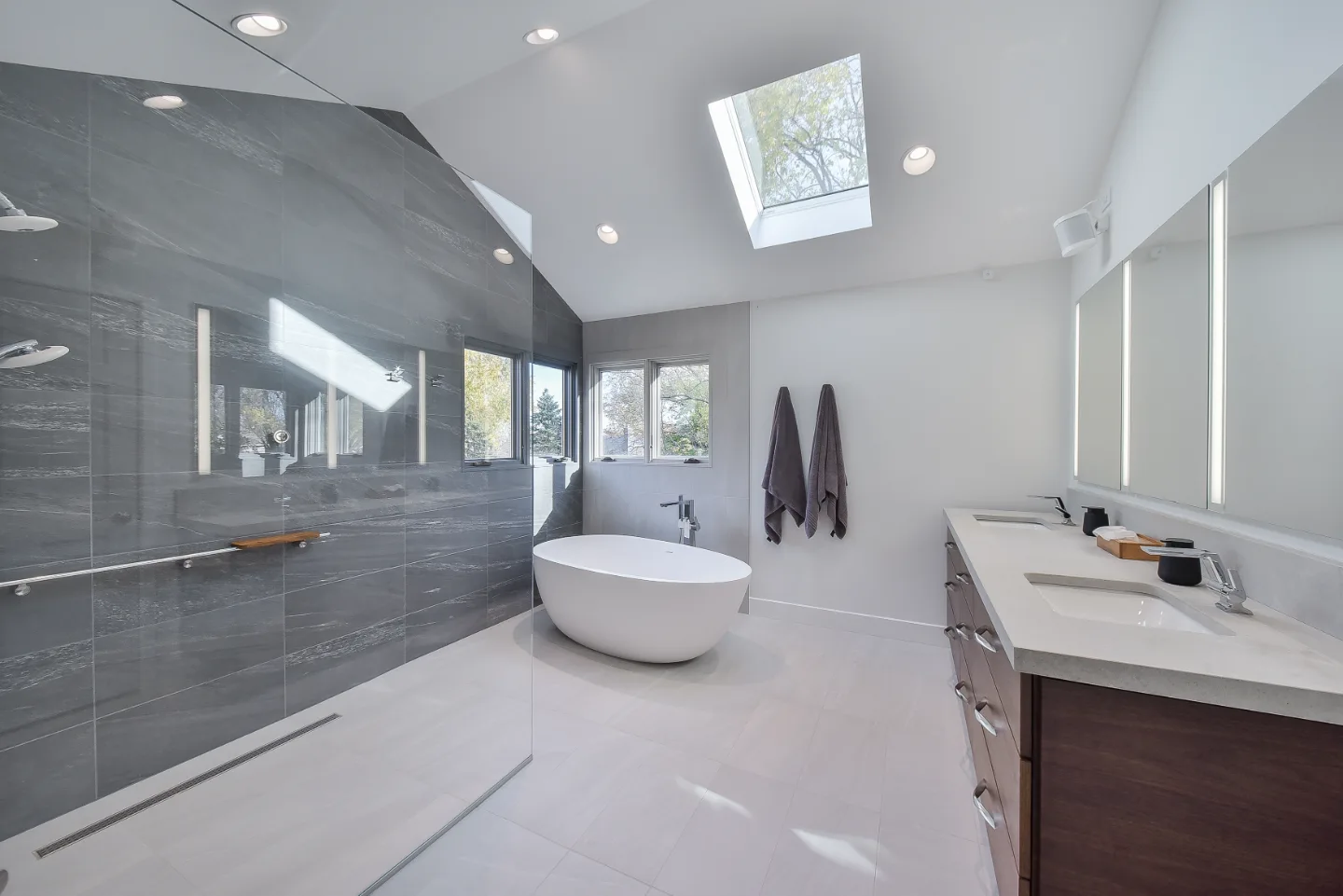 A modern-crisp primary bath remodel in Franklin, TN. CWP Walnut Ginger Slab cabinetry, CaesarStone Primordia quartz, Delta Pivotal Polished Chrome, and Virginia Tile Clash by Sebring Design Build.