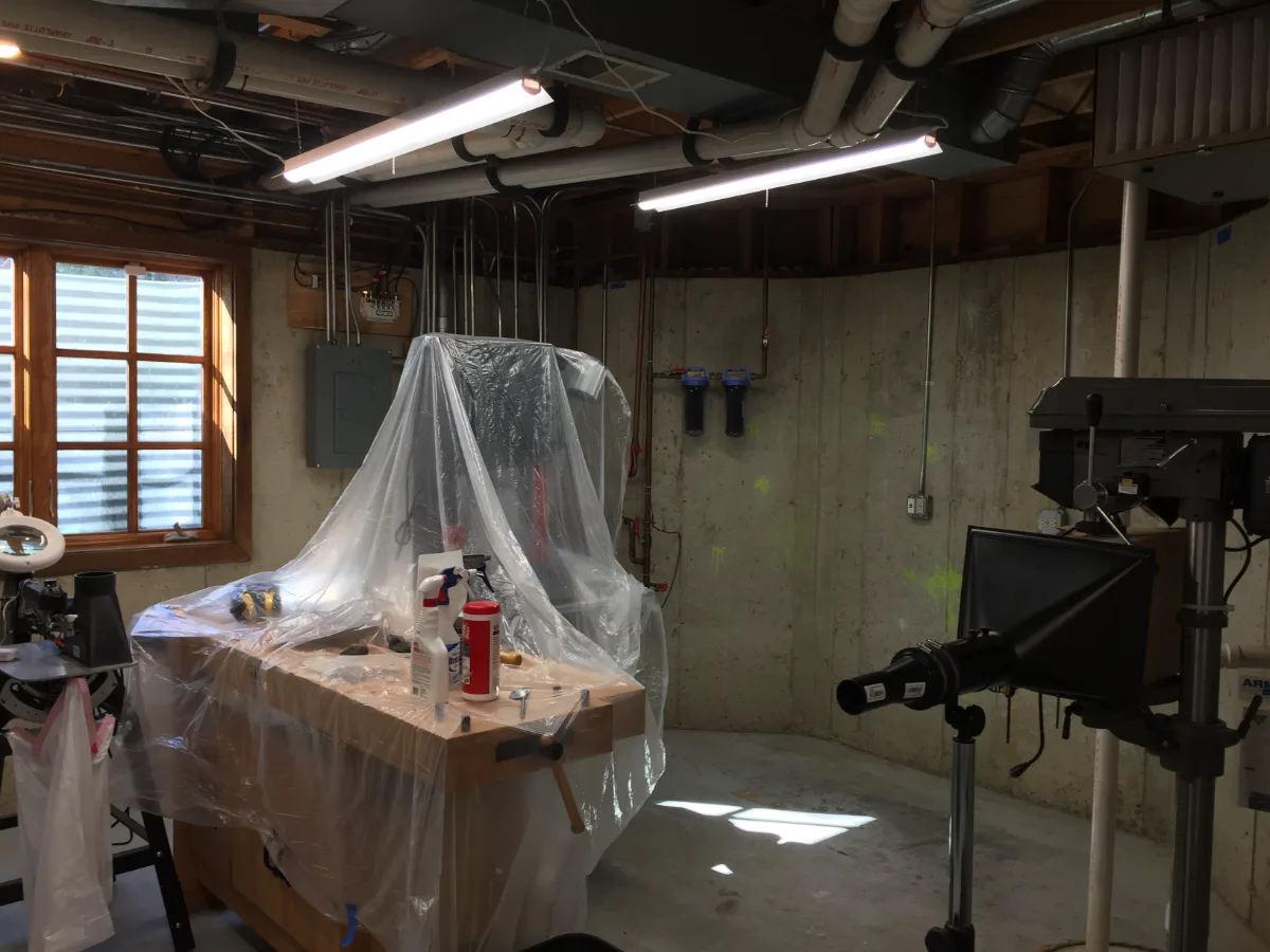 A functional-modern basement workshop in Franklin, TN. Concrete floor finish, designed for real work by Sebring Design Build.