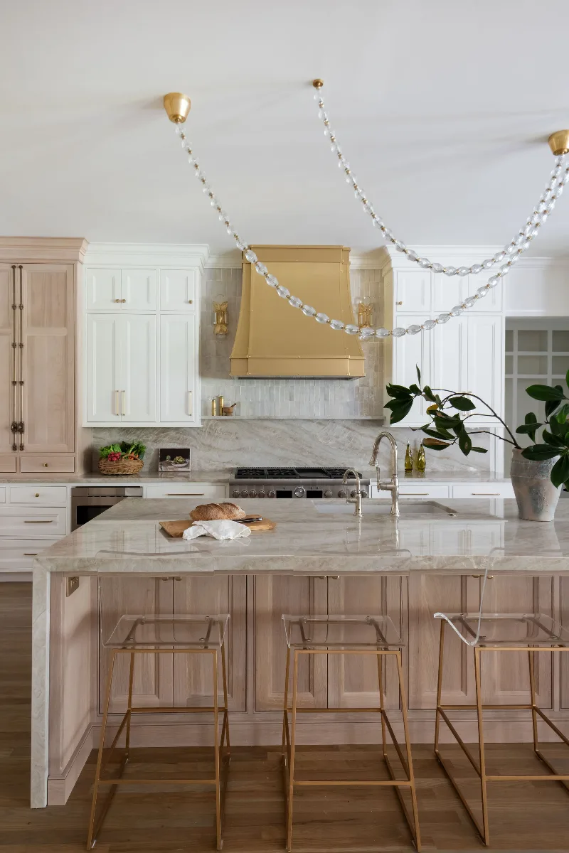 A modern-warm kitchen in Westhaven, Franklin TN 37064. CWP Dune and Tarragon cabinetry, custom brushed brass range hood, Calcutta Castana quartz, Natural White Zellige backsplash, and Patina Siren butler's pantry by Sebring Design Build.