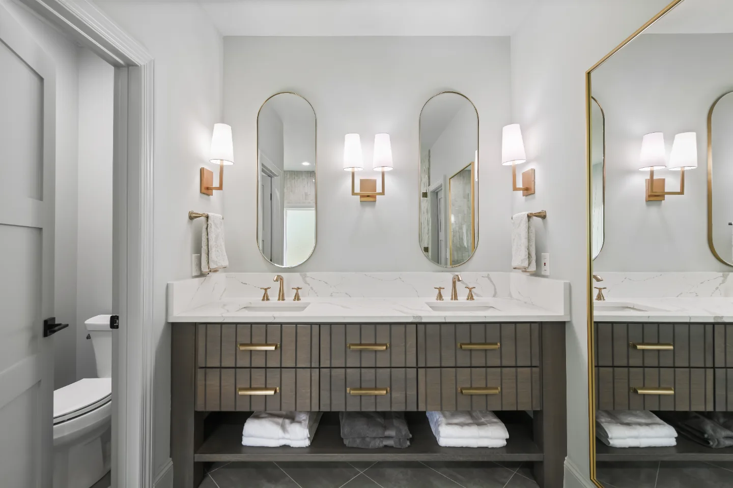 A modern-elegant primary bath in Watkins Creek, Franklin TN 37067. White Oak Flint Hills cabinetry, Mikado Calacatta Tree quartz, MTI freestanding tub, and Natural White Zellige shower walls by Sebring Design Build.