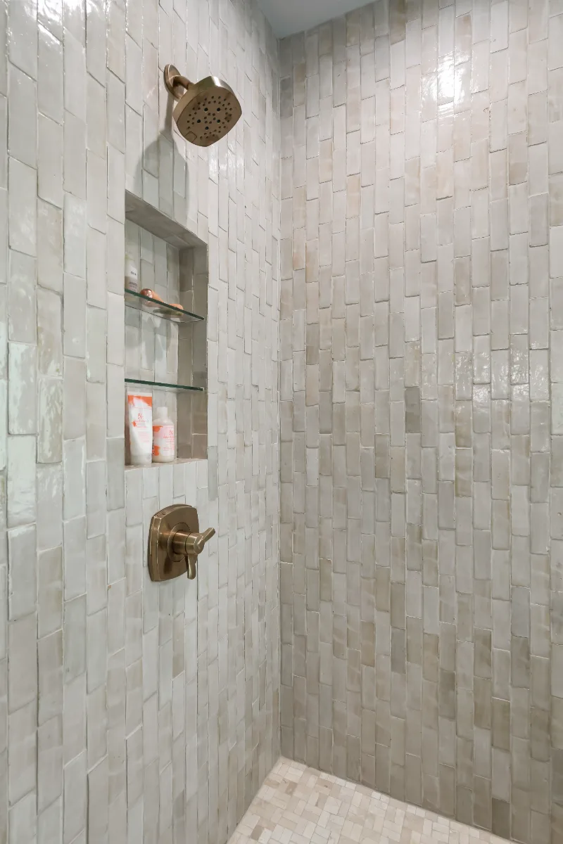 A modern-elegant primary bath in Watkins Creek, Franklin TN 37067. White Oak Flint Hills cabinetry, Mikado Calacatta Tree quartz, MTI freestanding tub, and Natural White Zellige shower walls by Sebring Design Build.