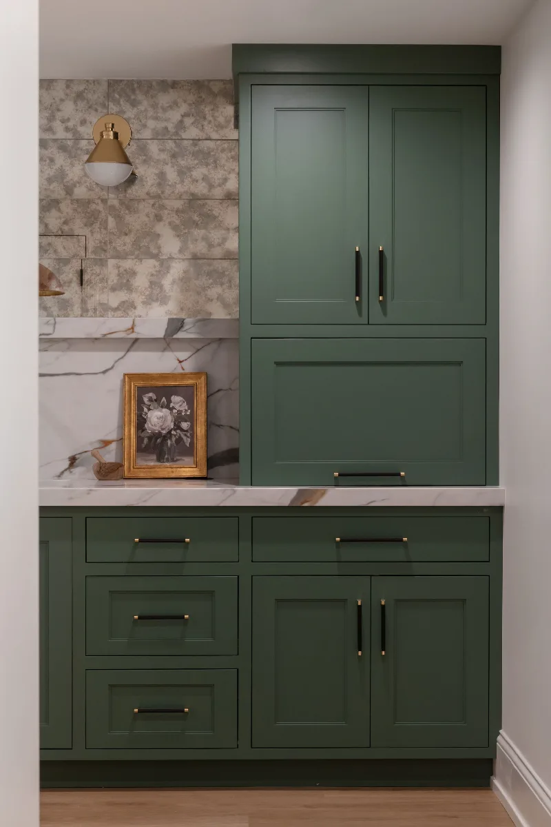 A modern-functional basement kitchenette in Bonbrook, Brentwood TN 37027. Kilimanjaro quartz with mitered edge, Patina Siren Mirror glass backsplash, and Delta Matte Black fixtures by Sebring Design Build.