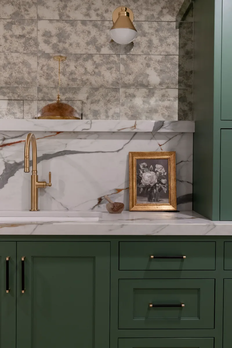A modern-functional basement kitchenette in Bonbrook, Brentwood TN 37027. Kilimanjaro quartz with mitered edge, Patina Siren Mirror glass backsplash, and Delta Matte Black fixtures by Sebring Design Build.
