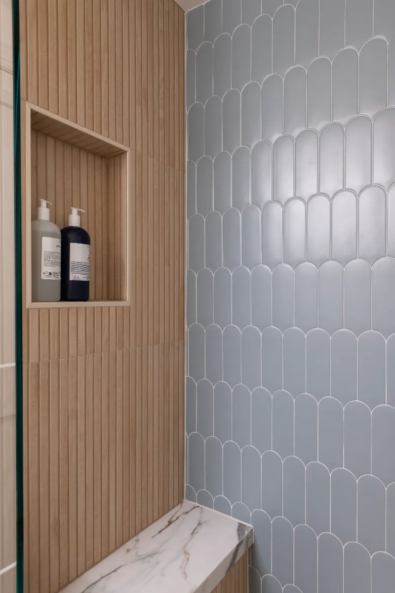 Guest Bath remodel in Franklin, TN. Sebring Design Build designed this Bonbrook basement guest bath in Brentwood, Tennessee with a modern-functional tile program featuring Kenridge Ribbon Maple shower walls.