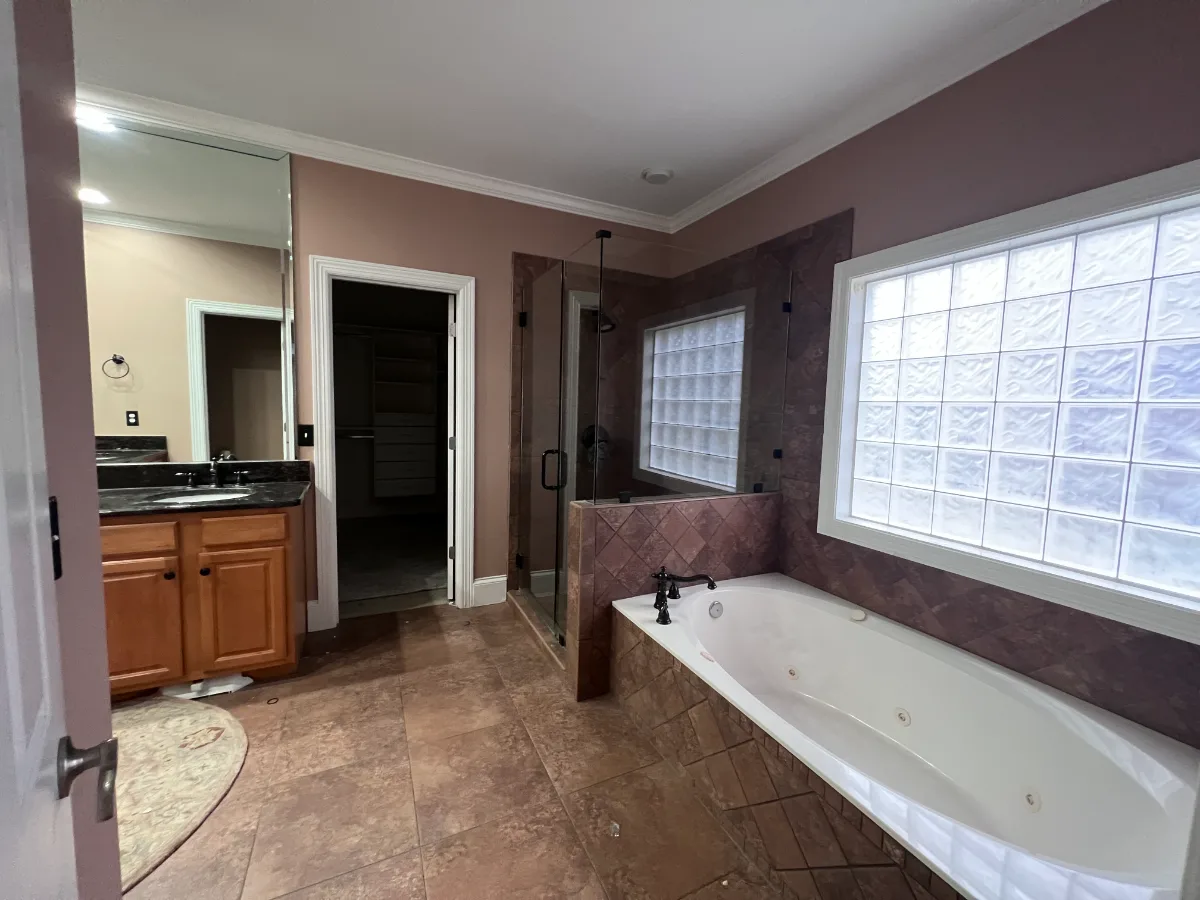 A modern-elegant primary bath in Watkins Creek, Franklin TN 37067. White Oak Flint Hills cabinetry, Mikado Calacatta Tree quartz, MTI freestanding tub, and Natural White Zellige shower walls by Sebring Design Build.
