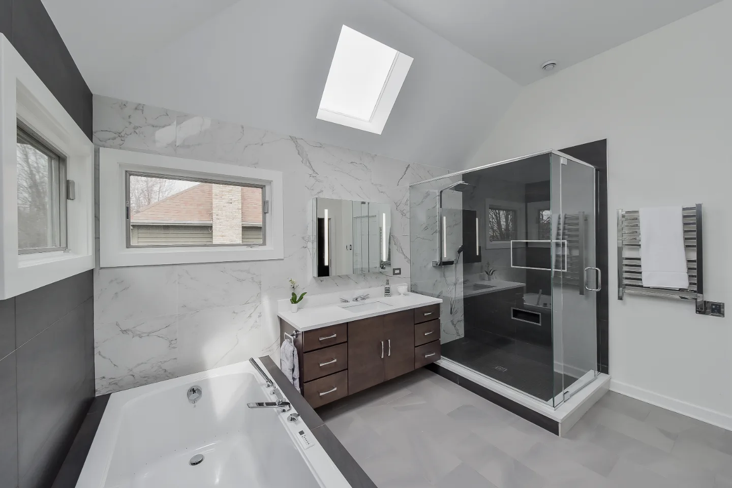 A modern-crisp primary bath remodel in Brentwood, TN. Wellborn Barcelona Oak Drift cabinetry, Orion Absolute White quartz, Atlas Concorde Calacatta Extra vanity wall, and Polished Chrome fixtures by Sebring Design Build.