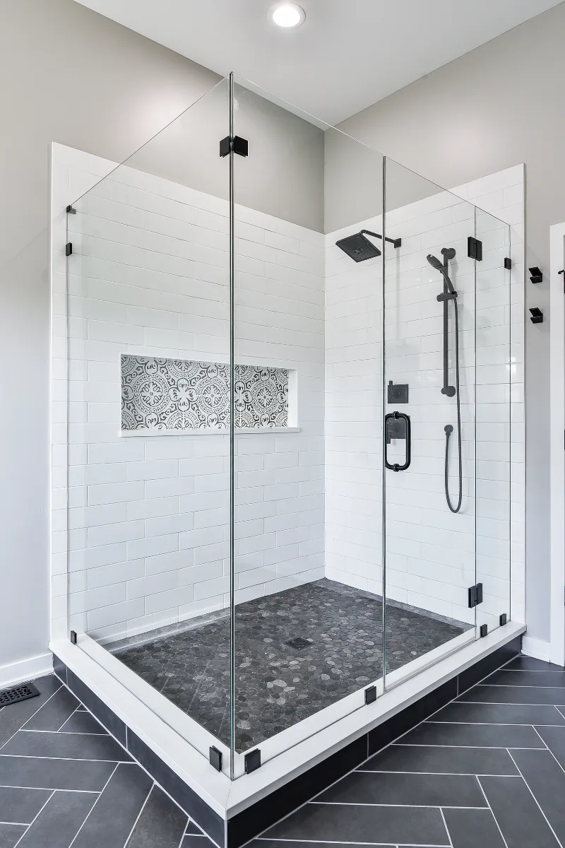 A modern-black-white primary bath remodel in Franklin, TN. Bellmont 1600 Studio White cabinetry, Cambria Deligatie quartz, Kohler Pivotal Matte Black, MTI Andrea tub, and MSI Kenzzi Paloma tile by Sebring Design Build.