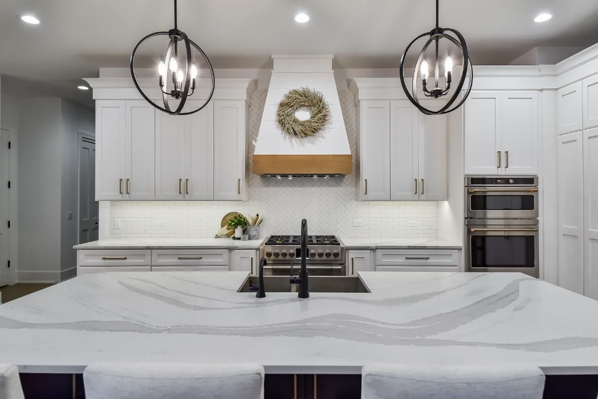 A transitional-elegant kitchen remodel in Franklin, TN. Snowbound and White Oak Sage cabinetry, Cambria Brittanicca Warm Matte quartz, and Zellige tile backsplash by Sebring Design Build.