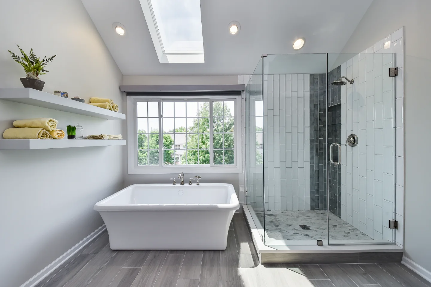 A modern-unique primary bath remodel in Brentwood, TN. Pearl cabinetry, Hanstone Tranquility quartz, MTI Rectangle soaking tub, Lunada Bay Aura Pearl accent tile, and Moen Polished Nickel by Sebring Design Build.