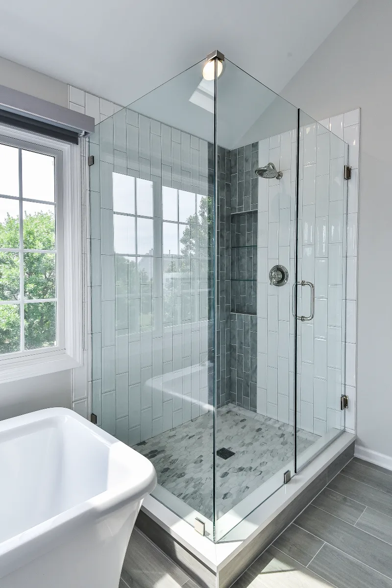 A modern-unique primary bath remodel in Brentwood, TN. Pearl cabinetry, Hanstone Tranquility quartz, MTI Rectangle soaking tub, Lunada Bay Aura Pearl accent tile, and Moen Polished Nickel by Sebring Design Build.