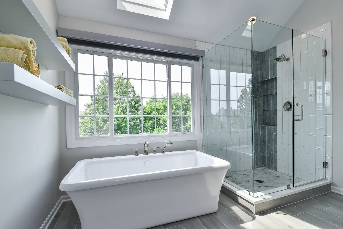 A modern-unique primary bath remodel in Brentwood, TN. Pearl cabinetry, Hanstone Tranquility quartz, MTI Rectangle soaking tub, Lunada Bay Aura Pearl accent tile, and Moen Polished Nickel by Sebring Design Build.