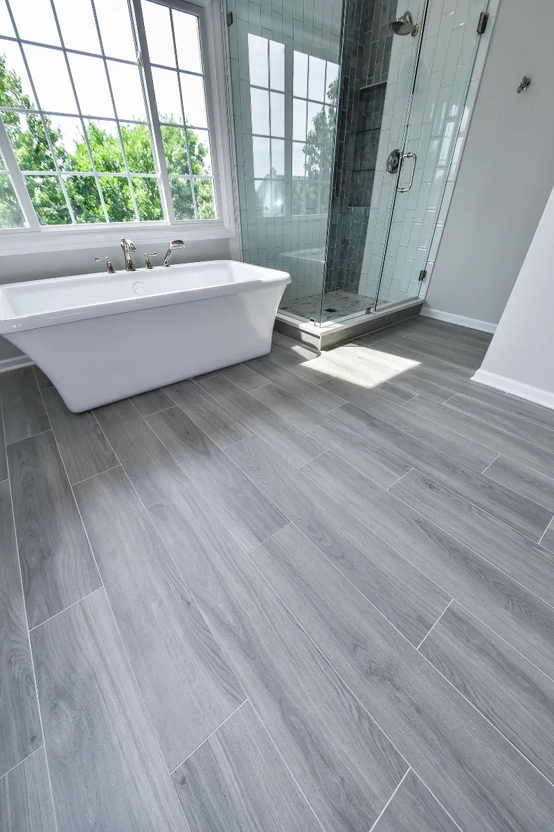A modern-unique primary bath remodel in Brentwood, TN. Pearl cabinetry, Hanstone Tranquility quartz, MTI Rectangle soaking tub, Lunada Bay Aura Pearl accent tile, and Moen Polished Nickel by Sebring Design Build.