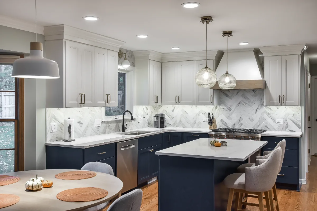 A modern-coastal kitchen remodel in Brentwood, TN. Two-tone cabinetry in Soft White and Midnight, Caesarstone Calacatta Nuvo, and Matte Black fixtures by Sebring Design Build.