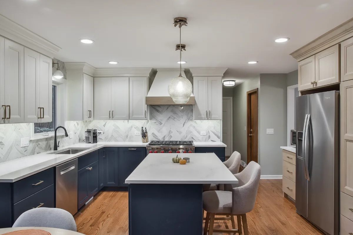 A modern-coastal kitchen remodel in Brentwood, TN. Two-tone cabinetry in Soft White and Midnight, Caesarstone Calacatta Nuvo, and Matte Black fixtures by Sebring Design Build.