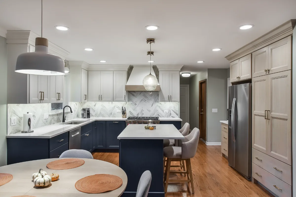 A modern-coastal kitchen remodel in Brentwood, TN. Two-tone cabinetry in Soft White and Midnight, Caesarstone Calacatta Nuvo, and Matte Black fixtures by Sebring Design Build.