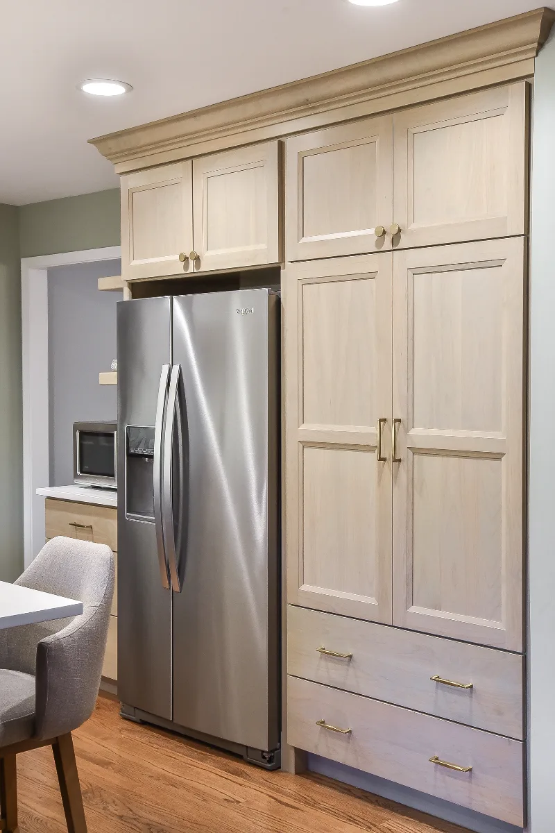 A modern-coastal kitchen remodel in Brentwood, TN. Two-tone cabinetry in Soft White and Midnight, Caesarstone Calacatta Nuvo, and Matte Black fixtures by Sebring Design Build.