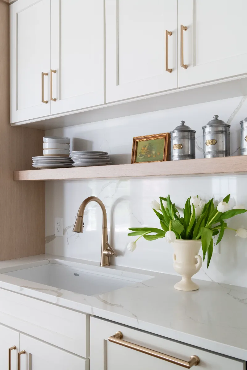 A coastal-elegant kitchen remodel in Willowsprings, Franklin TN 37064. Custom Champagne cabinetry, Calacatta Gold quartz, and Champagne Bronze fixtures by Sebring Design Build.