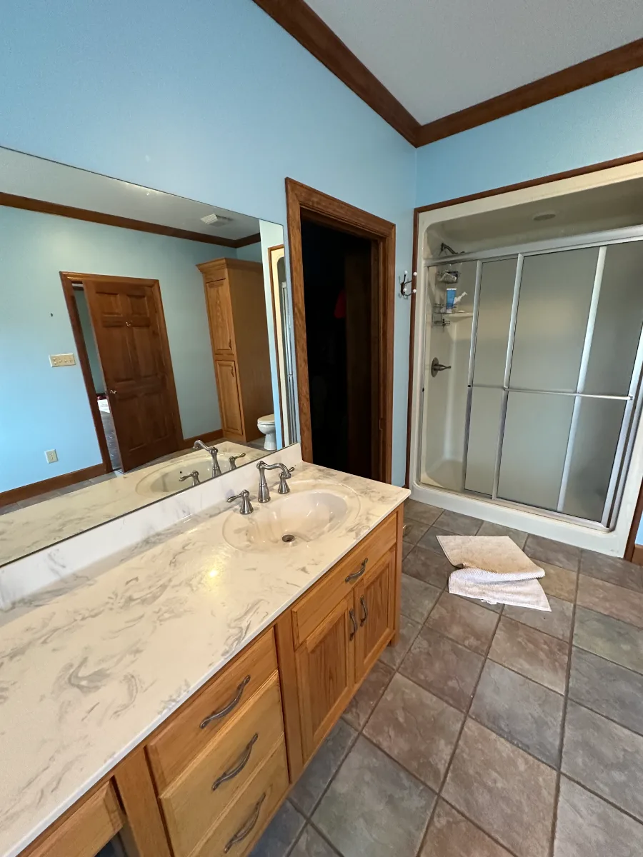 A transitional-bold primary bath remodel in Columbia, TN. White Oak quarter-sawn cabinetry, Calacatta Monaco quartz, and a bold Kenridge Ribbon Black feature wall by Sebring Design Build.