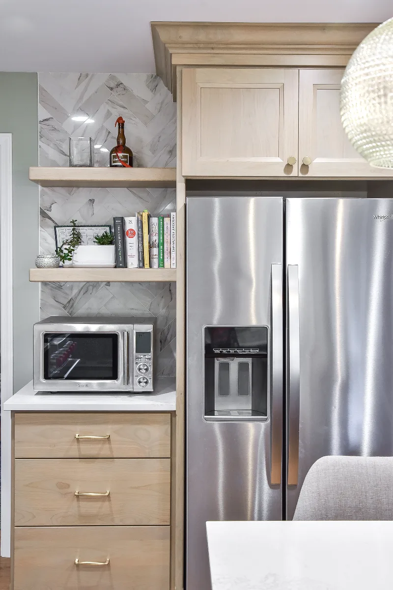 A modern-coastal kitchen remodel in Brentwood, TN. Two-tone cabinetry in Soft White and Midnight, Caesarstone Calacatta Nuvo, and Matte Black fixtures by Sebring Design Build.