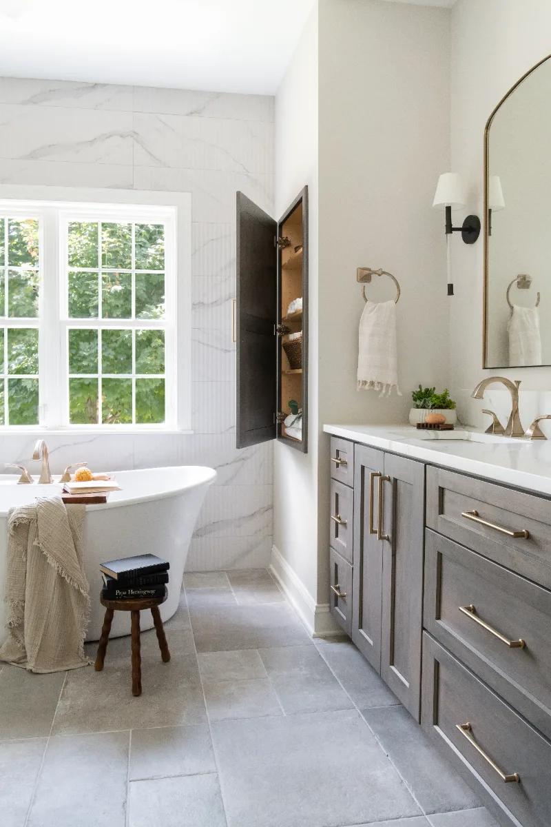 A coastal-elegant primary bath remodel in Willowsprings, Franklin TN 37064. Alder cabinetry, Calacatta Gold quartz, and Kohler Champagne Bronze by Sebring Design Build.