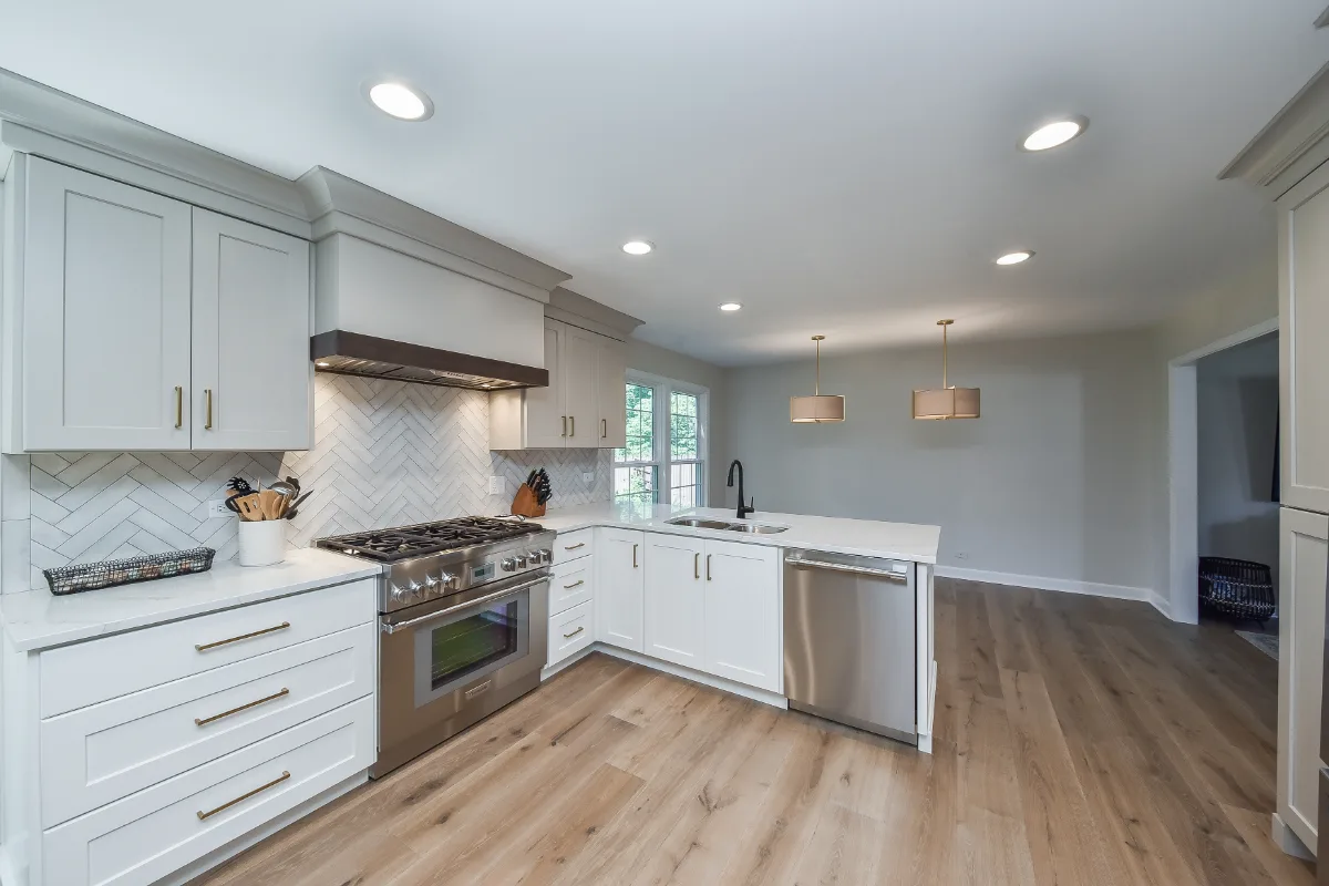 A Franklin, TN kitchen remodel with custom cabinetry in soft white, dune, and Puget Sound blue. Calacatta Aria quartz and Berenson Metro hardware by Sebring Design Build.