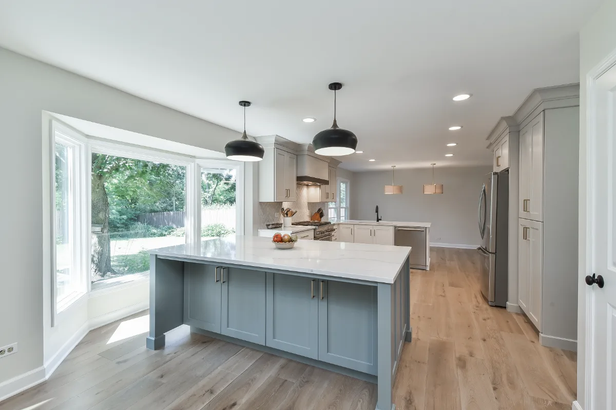 A Franklin, TN kitchen remodel with custom cabinetry in soft white, dune, and Puget Sound blue. Calacatta Aria quartz and Berenson Metro hardware by Sebring Design Build.