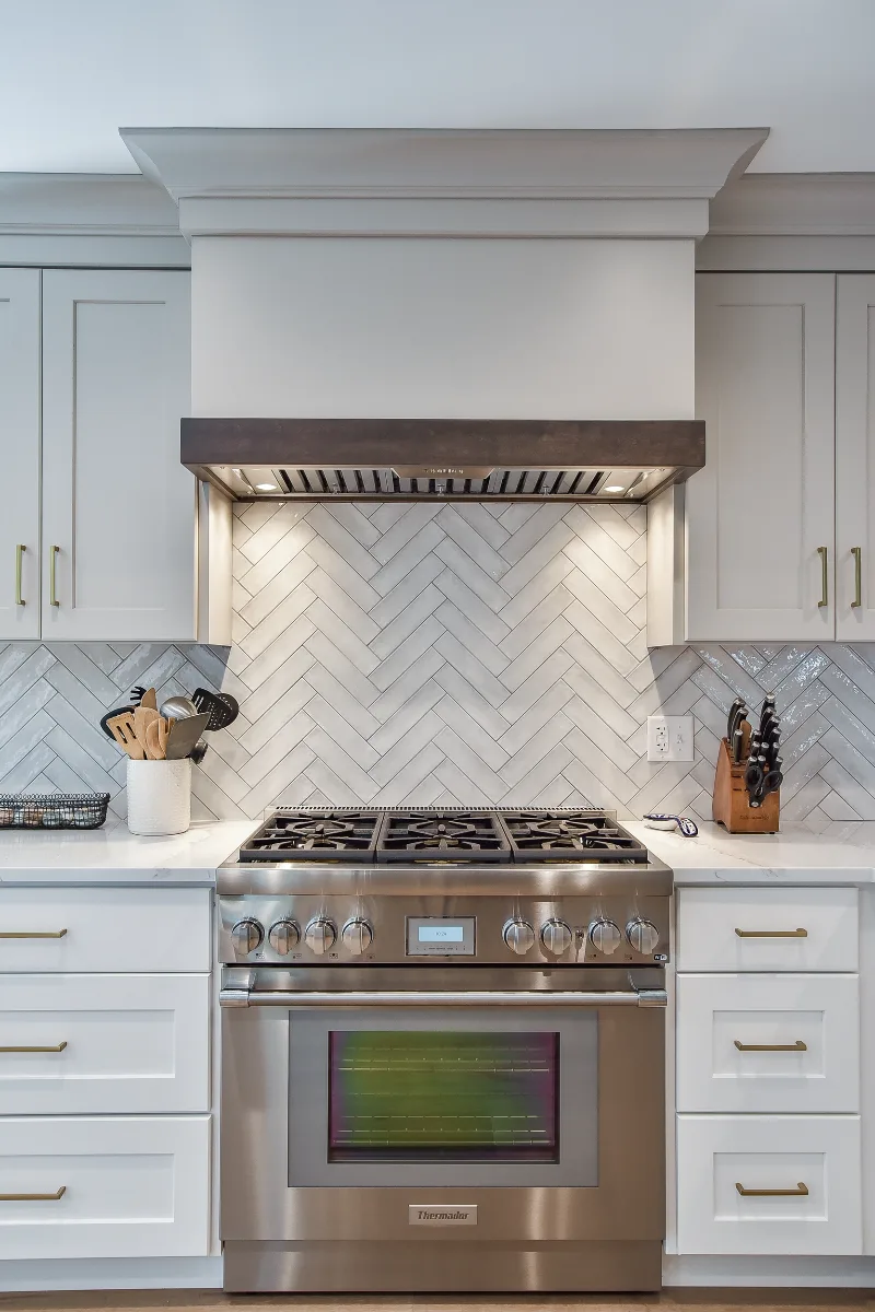 A Franklin, TN kitchen remodel with custom cabinetry in soft white, dune, and Puget Sound blue. Calacatta Aria quartz and Berenson Metro hardware by Sebring Design Build.